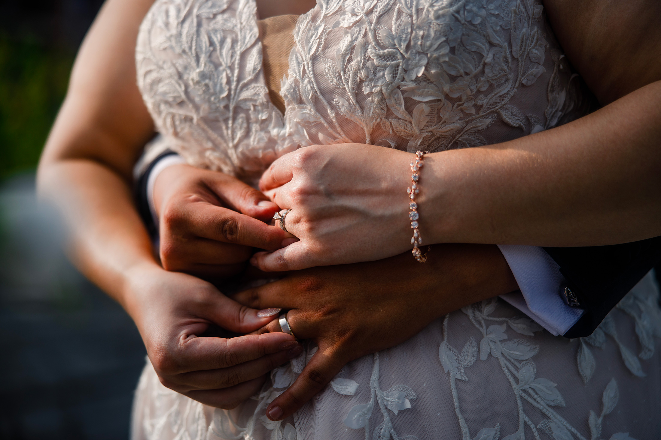 Close-up of wedding rings as couple holds hands